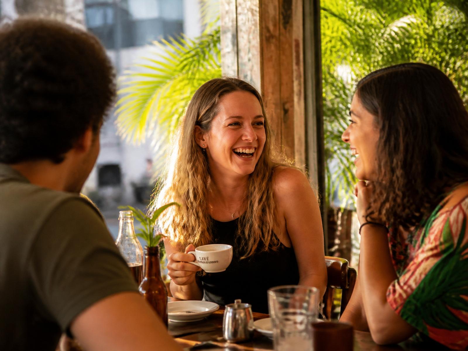 Americana conversando com brasileiros em um café ensolarado